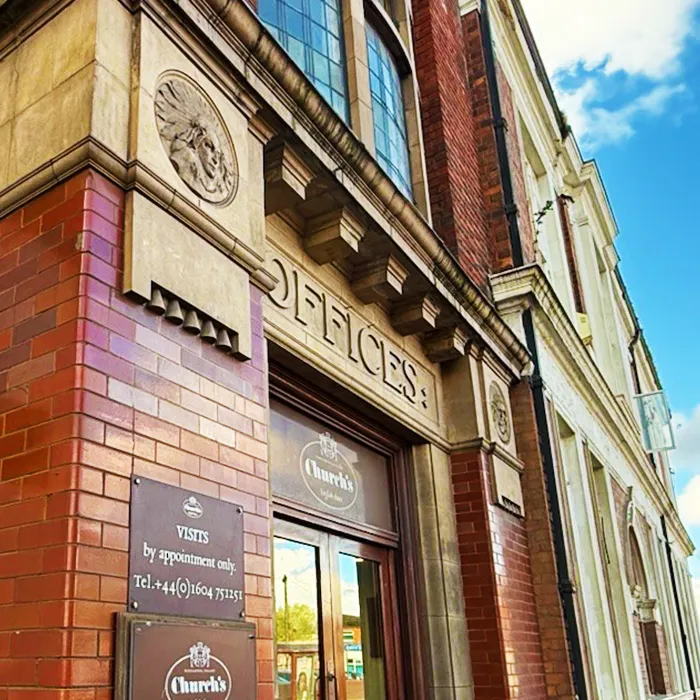 A brick building facade with "offices" carved above the entrance and "church's" signage on the doors