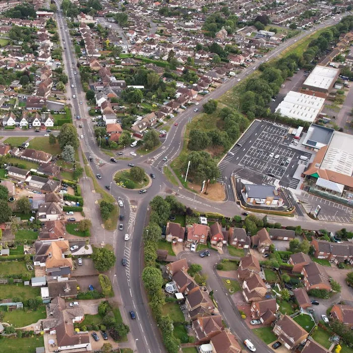 Aerial view of a suburban town with a roundabout, retail park and rows of houses