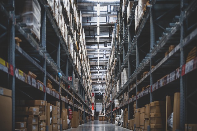 A warehouse aisle lined with tall shelving stacked with cardboard boxes